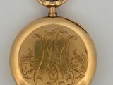 gold plated pocket watch with engraved design on the front