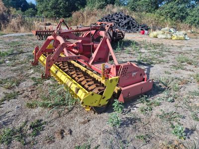 un engin agricole rouge et jaune dans un champ