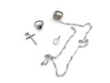 a silver necklace, ring, and other jewelry on a white surface