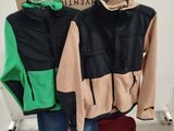 a pile of clothes on a rack in a room
