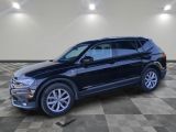 un SUV Volkswagen noir garé dans un garage au sol carrelé