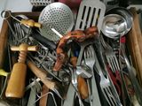 une boîte remplie d'ustensiles de cuisine posée sur un plan de travail