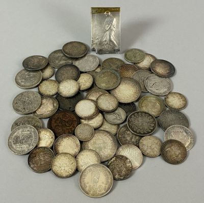 a pile of silver coins with a small silver coin in the middle of it