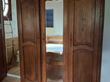 une grande armoire en bois avec un miroir sur la porte