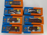 six boîtes contenant des petits trains posées sur une surface blanche