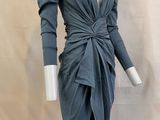 Le mannequin porte une robe grise à manches longues.