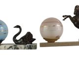 trois figurines posées sur une étagère avec un œuf