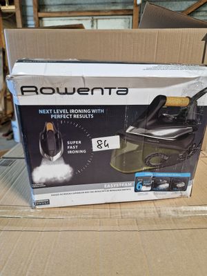 La boîte d'un fer à repasser à vapeur est posée sur un carton