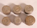 six old metal knobs sitting on top of a white surface