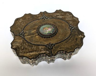 an image of a silver box with a picture of a woman on it