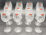 six clear wine glasses are lined up in a row on a table