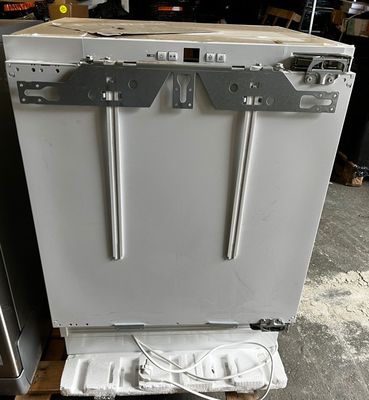 a white dishwasher sitting on a pallet in a garage