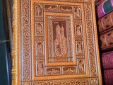 un vieux livre posé sur une étagère en bois, à côté d'une pile de livres