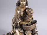 bronze figurine of a woman washing a child in a bowl