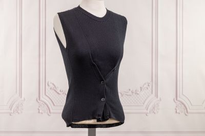 gilet noir sans manches sur un socle de mannequin
