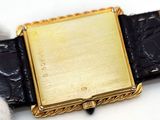 a gold watch with a black leather band