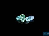 a couple of blue and green gems sitting on top of a black surface