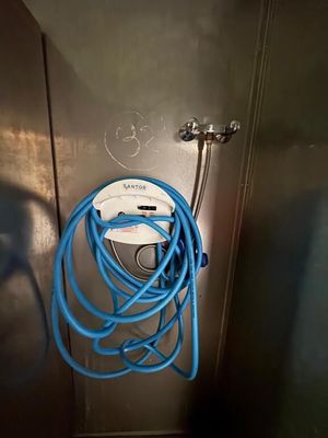 un tuyau bleu fixé au mur d'une salle de bains