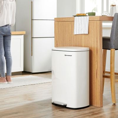 a woman standing at a kitchen table in front of a white air purifier