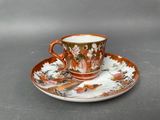 an orange and white cup and saucer sitting on top of a saucer