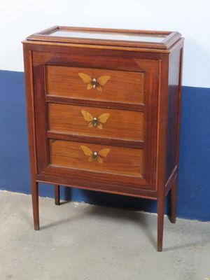 a small wooden chest of drawers with a glass top