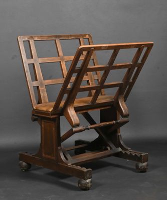 une paire de chaises anciennes en bois montées sur roulettes, sur fond gris