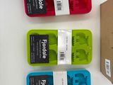 four different colored ice trays in a cardboard box on a table