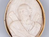 un gros plan sur une plaque en pierre blanche représentant un homme coiffé d'un chapeau