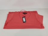 a red shirt with a tag on it sitting on a white surface