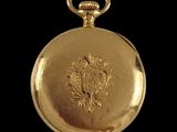 an image of a gold pocket watch on a black background