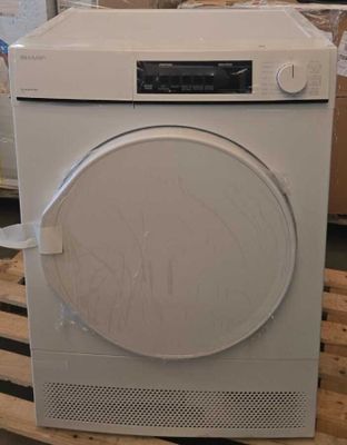 une machine à laver blanche posée sur une palette dans un entrepôt