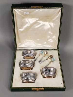 un assortiment d'argenterie dans un coffret vert posé sur une table