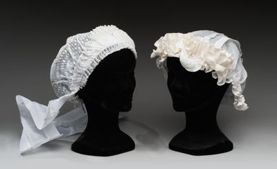 deux têtes de mannequins coiffées de chapeaux blancs ornés de fleurs blanches