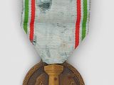 an old medal with a cross on it sitting on a white surface
