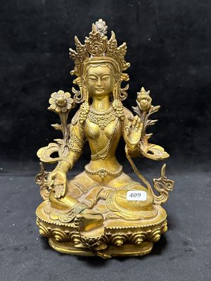 une statue en or représentant une femme assise sur une table