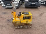 un bulldozer jaune posé par terre à côté d'autres camions