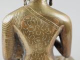 a gold statue of a woman sitting on a stool