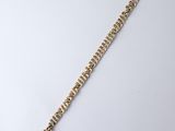 a close up of a gold chain bracelet on a white surface