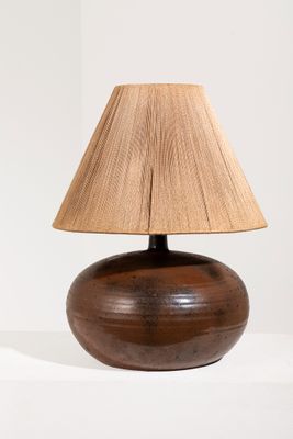 une lampe en bois munie d'un abat-jour marron