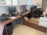 a desk with two computers and a printer on it