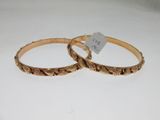 pair of gold tone bangles with engraved design on each side