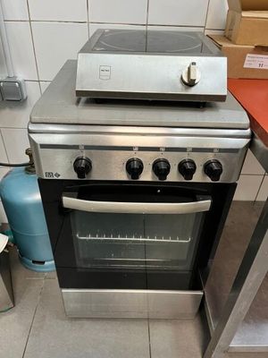 une cuisinière qui se trouve dans une cuisine, à côté d'un plan de travail