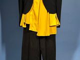 a mannequin wearing a yellow top and black pants