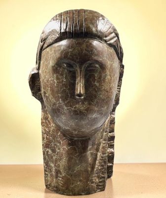 un gros plan sur la sculpture d'une tête de femme posée sur une table