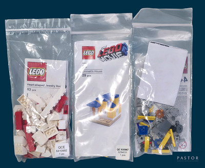 trois sachets de Lego posés sur une surface bleue