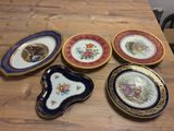 four plates with different designs on them sitting on a wooden table
