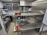 une grande cuisine avec des plans de travail et des étagères en inox