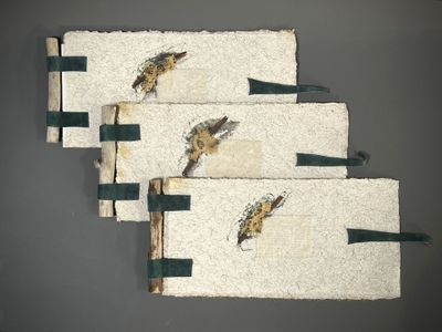 Trois serviettes blanches ornées d'oiseaux sont accrochées au mur.