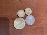 four different coins sitting on top of a table next to each other