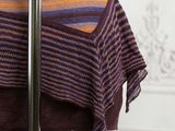 a purple and orange striped shawl hanging on a pole